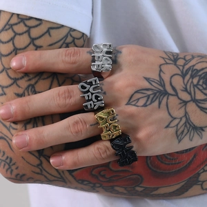 Macro detail of retro stainless steel punk rings with bold letter engraving on fingers
