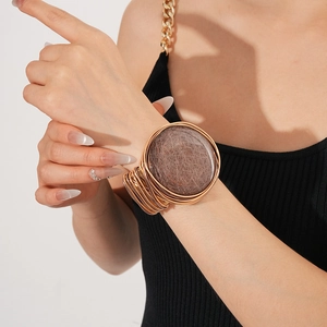 Detail shot of vintage resin armlet with gold wire wrap on model's arm