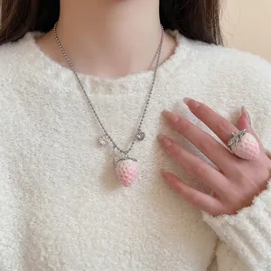 Pink velvet strawberry necklace and ring jewelry set worn on a cozy white knit sweater