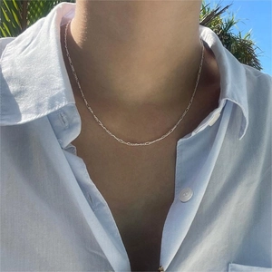Elegant 925 sterling silver Figaro chain necklace worn by a model against a blue sky