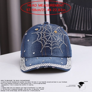 Detailed view of silver rhinestones on a blue denim baseball cap with spider web pattern