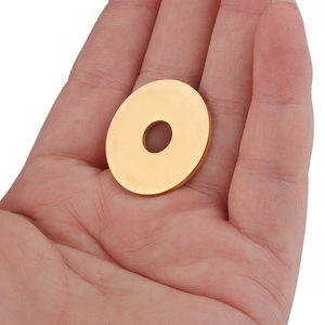 Macro view of a 25mm polished gold round pendant charm held in hand for size reference