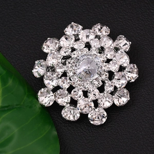 Macro view of a sparkling silver flower brooch with clear rhinestones on a leaf