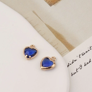 Détail de deux pendentifs en cristal bleu en forme de cœur avec monture dorée