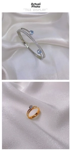 Detailed view of titanium steel jewelry set featuring blue gemstone accents on silk background