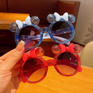 Close-up of kids glittery round sunglasses with cute ears and bow tie decorations