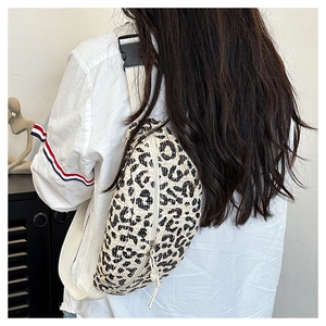 Detailed back view of a woman wearing the leopard print waist bag with woven texture