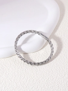 Macro detail of silver braided stainless steel cuff bracelet with polished columnar clasp