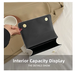 Detail of open flap crossbody bag showing spacious interior and golden magnetic closures