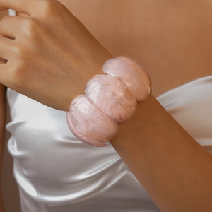 Macro view of wide marble pink acrylic resin bracelet with smooth modular segments