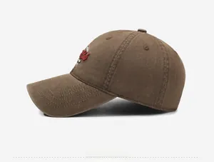 Side view of dark brown vintage washed cotton baseball cap with red and white embroidery