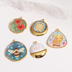 Close-up of five oval titanium steel pendants with colorful floral and animal prints