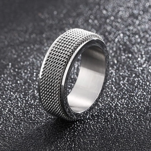 Macro detail of silver stainless steel spinner ring with intricate braided mesh texture