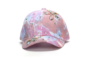 Dettaglio cappellino bimbi con sfumatura rosa e motivi floreali in strass colorati