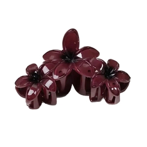 Elegant deep burgundy flower hair claw clip with triple frangipani design on white background