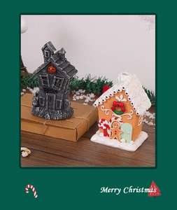 Detail of Christmas gingerbread house and Halloween ghost house resin ornaments on wood