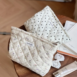 Close-up of quilted floral and heart pattern corduroy pouches with simple wish label