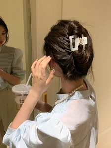 Iridescent white square acetate hair claw clip styled on a brunette half-up hairstyle
