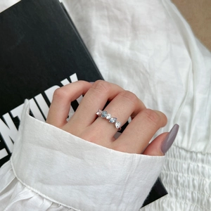 Detailed view of an elegant S925 silver ring with blue heart and white zircon stones on hand