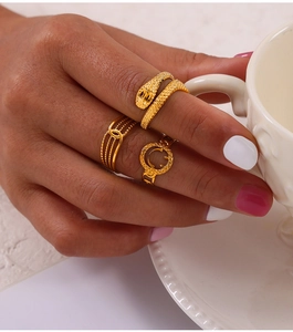 Detailed close-up of a three-piece gold geometric ring set worn on a model's hand