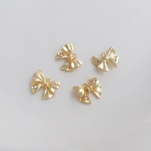 Macro detail of 14K gold-filled bow charms with cubic zirconia for DIY jewelry making