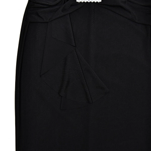 Detail of black bodycon dress featuring elegant ruffles and a sparkling rhinestone buckle