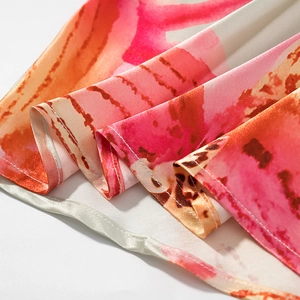 Détail macro de l'ourlet de robe en satin avec coutures fines et imprimé fleuri rose