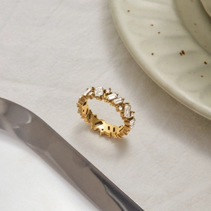 Makroaufnahme eines 18K Gold Edelstahlrings mit rechteckiger Zirkonia-Einlage auf Leinen
