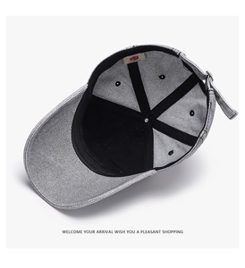 Internal detail of grey baseball cap showing black sweatband and metal adjustment buckle