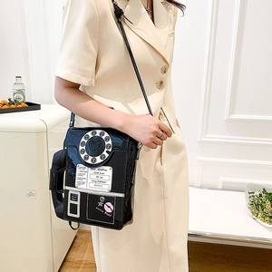 Close-up of retro black patent leather telephone bag featuring vintage dial design details