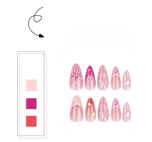 Détail de breloques papillon 3D et perles sur faux ongles amande rose en dégradé français
