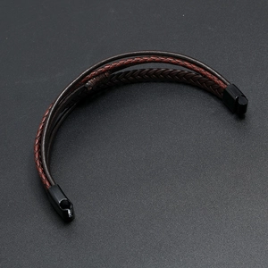 Detail showing the woven dark brown and red leather cords with black magnetic metal clasp