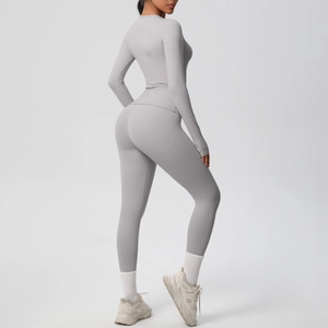Dettaglio dei leggings grigi a vita alta e del top sportivo a maniche lunghe coordinato