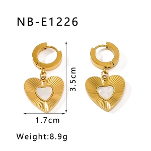 Detail view of heart pendant earrings in 18k gold plating with white mother of pearl