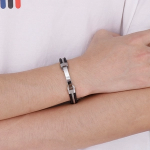 Close-up of men's braided leather and steel bracelet with polished silver metal pieces