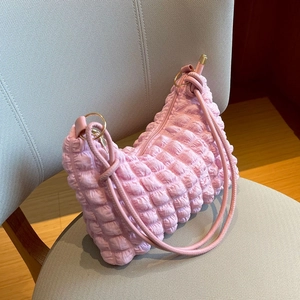 Dettaglio della borsa rosa con trama a bolle, tessuto a pieghe e fibbia in metallo dorato