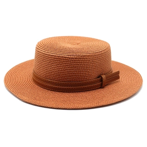 Detailed weave of tan boater hat featuring a brown faux leather band with dual stitching