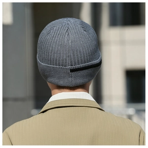 Detail view of dark grey ribbed knit beanie featuring black horizontal stripes on the back
