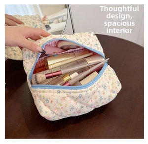 Quilted floral makeup bag with light blue zipper showing spacious interior storage