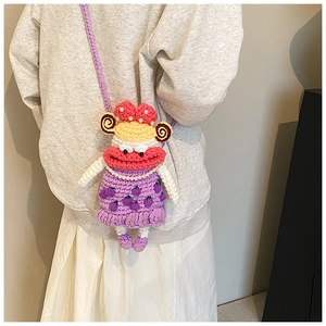 Detail of crochet crossbody bag with funny cartoon face, thick pink lips and pearl beads