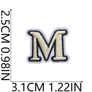 Detailed view of beige and navy embroidered letter M patch with size measurements
