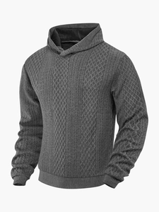 Detail eines dunkelgrauen Herren-Kapuzenpullovers mit Rautenmuster und Zopfstrick-Textur
