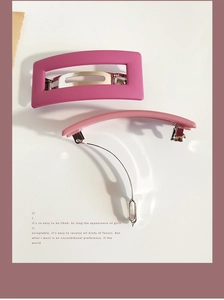 Close-up of pink matte hair clips in rectangular and slim shapes with metal spring