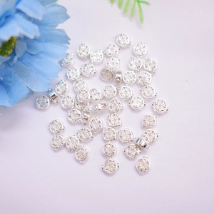 Silver hollow flower pattern spacer beads for DIY jewelry making on white background