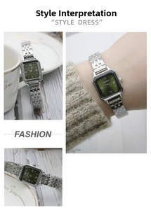 Macro detail of silver steel watch band and emerald green sunray dial with Roman numerals
