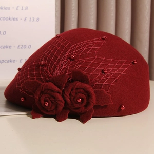 Detail of burgundy wool beret featuring handmade roses, delicate mesh, and red beads
