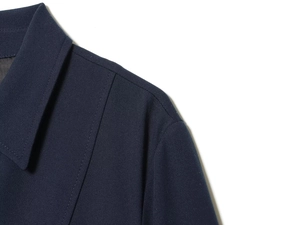 Detail shot of navy blue twill fabric texture and spread collar stitching on the dress