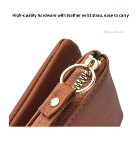 Detailed shot of brown leather wallet zipper, premium gold metal hardware and stitching.