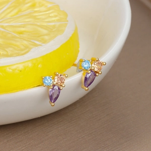 Detailed shot of golden butterfly earrings with blue, purple and champagne zircons