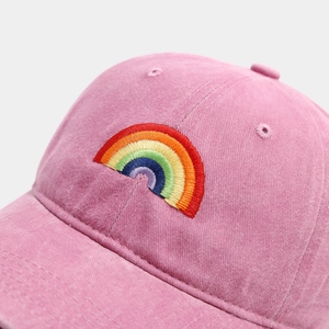 Close-up of rainbow embroidery on a vintage pink washed cotton baseball cap